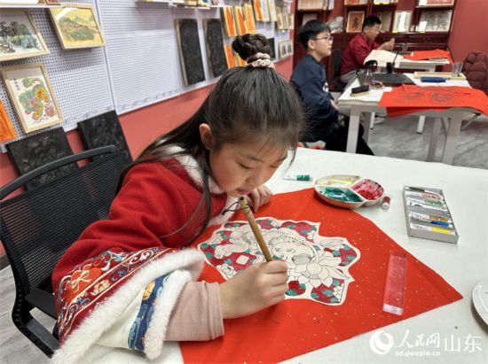 小學(xué)生在社教研學(xué)項(xiàng)目中給年畫填色。 人民網(wǎng) 喬姝攝